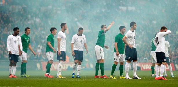 Jogadores de Inglaterra e Irlanda em meio à fumaça durante o amistoso no estádio de Wembley