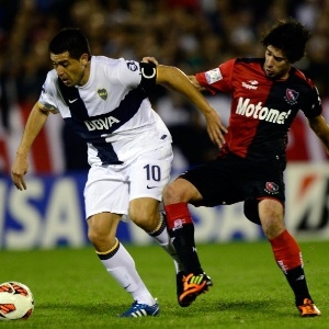29.mai.2013 - Riquelme, meia do Boca, tenta passar pela marcação de dois jogadores do Newell's durante jogo em Rosário - undefined