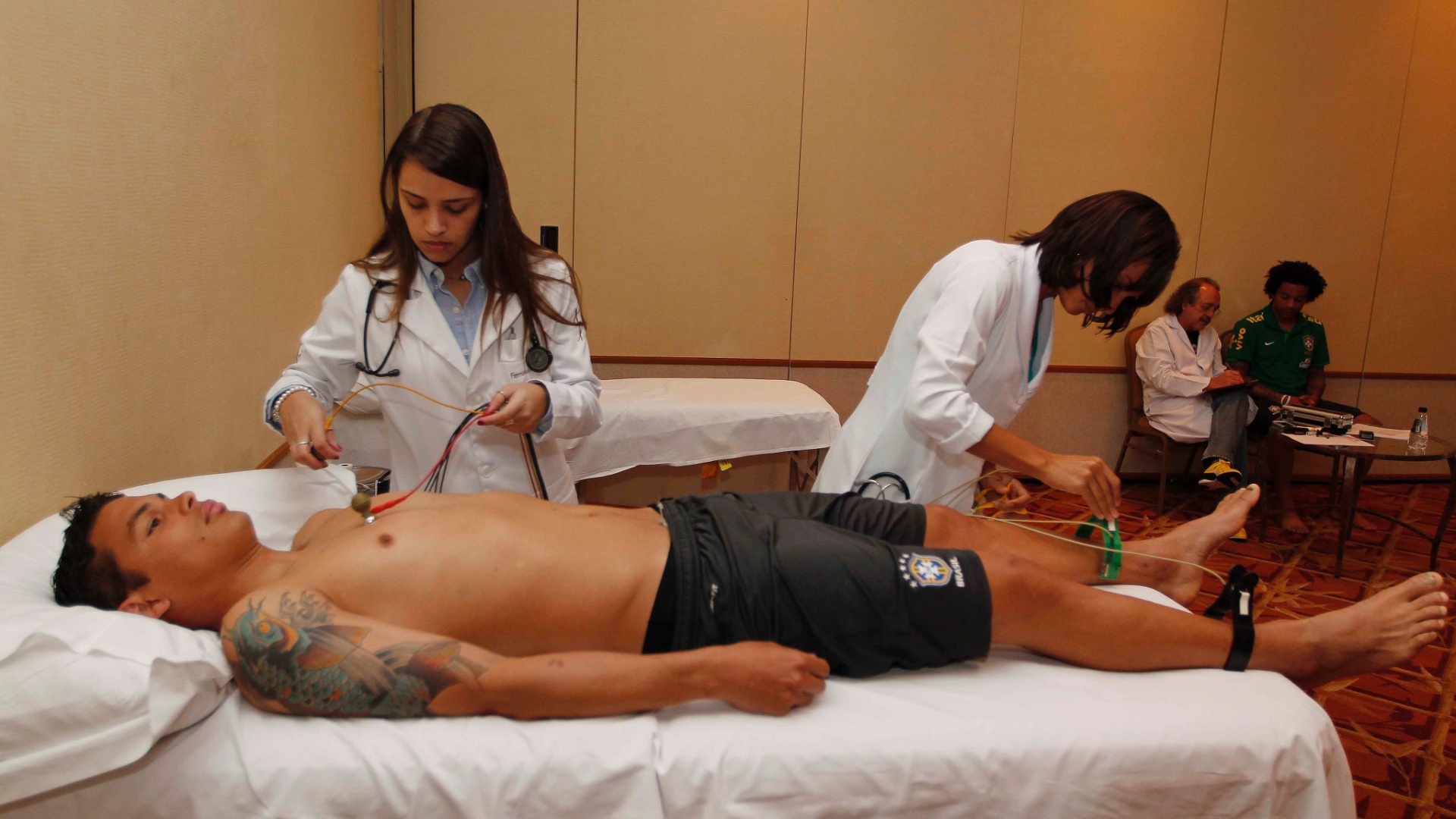 29.mai.2013 - Zagueiro Thiago Silva é examinado por duas médicas da seleção brasileira