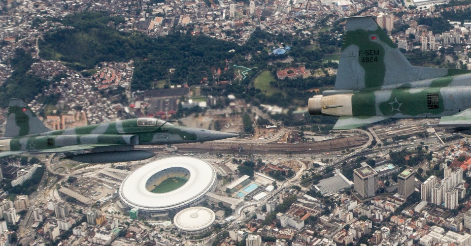 No céu do Rio de Janeiro, dois caças F5M se aproximam de aeronave não identificada para dominar a situação, em exercício da FAB