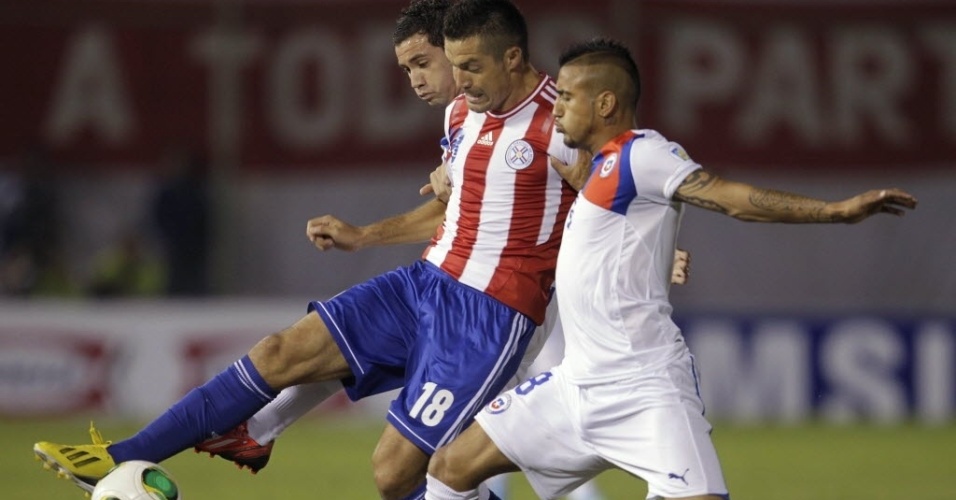 07.jun.2013 - Arturo Vidal marca de perto Dante Lopez na partida entre Chile e Paraguai pelas Eliminatórias da América do Sul