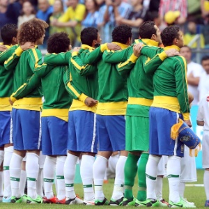Jogadores da seleção brasileira abraçados durante hino nacional antes de amistoso contra a França