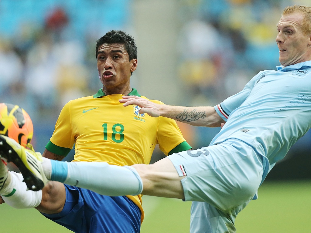 09.jun.2013 - Volante Paulinho tenta ganhar dividida com Mathieu durante amistoso entre Brasil e França