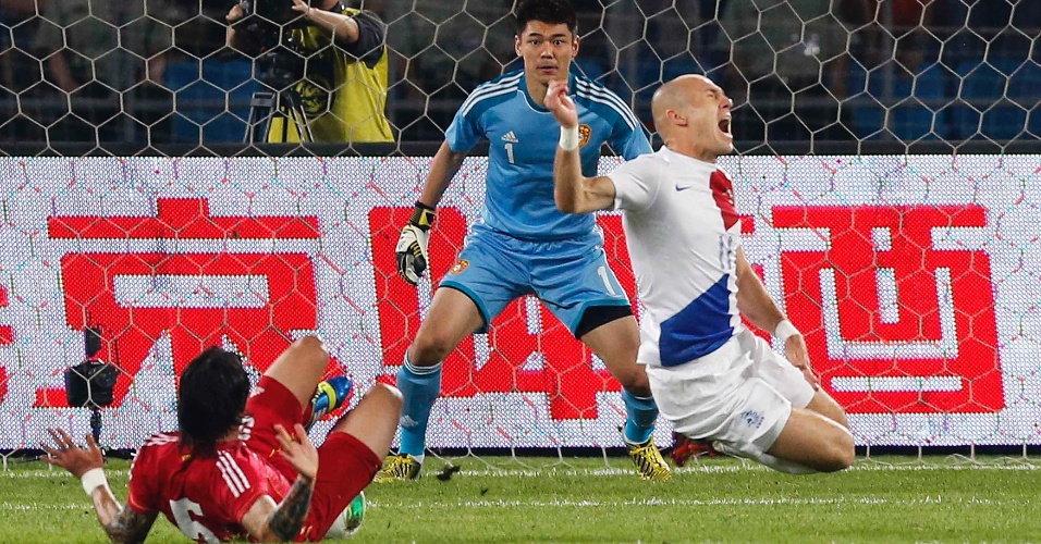 11.jun.2013 - Arjen Robben é derrubado por Zhang Linpeng dentro da área durante amistoso entre China e Holanda em Pequim