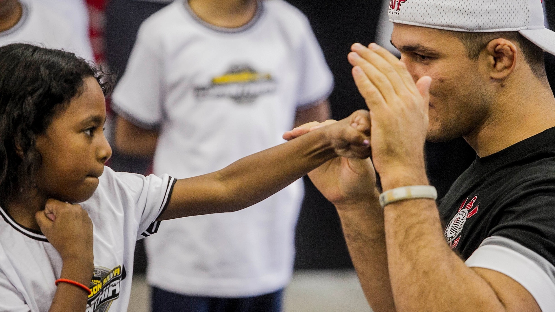 11.jun.2013 - Junior Cigano ensina luta a garota em campanha social do Corinthians no Parque São Jorge - Leonardo Soares/UOL