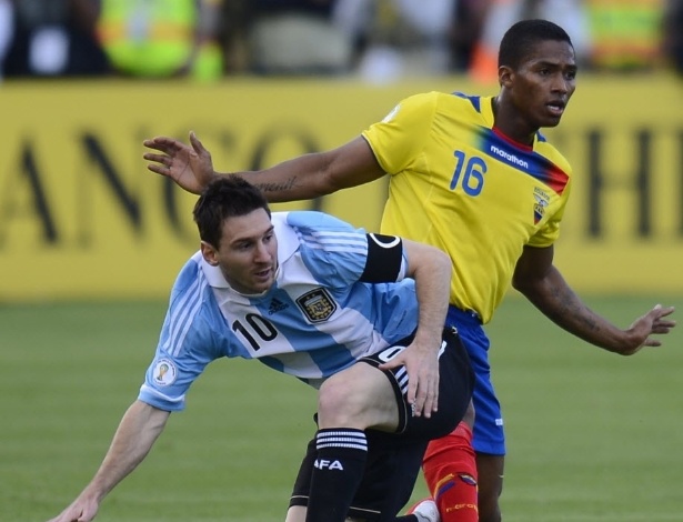 11.jun.2013 - Lionel Messi (esq.), da Argentina, e Valencia, do Equador, disputam a posse da bola em partida das Eliminatórias para a Copa do Mundo