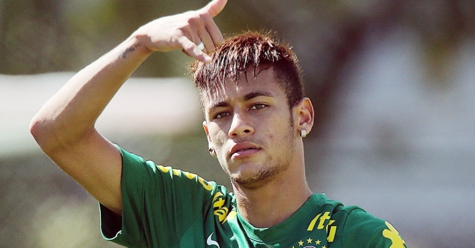 12.jun.2013 - Neymar faz sinal para a torcida no treino desta quarta, que foi aberto ao público, em Goiânia
