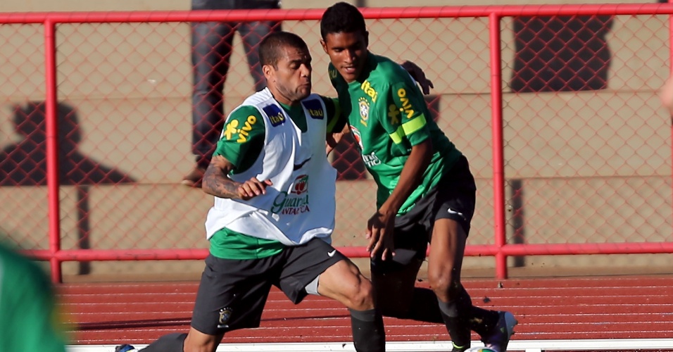 13.jun.2013 - Daniel Alves (esq.) e Paulinho disputam a bola durante treino da seleção brasileira nesta quinta-feira