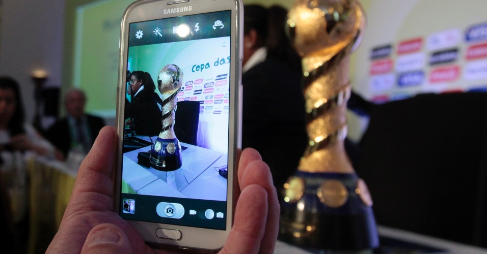 13.jun.2013 - Jornalista registra imagens do troféu da Copa das Confederações durante evento em que dirigentes da Fifa e da CBF falaram sobre os últimos preparativos para a competição