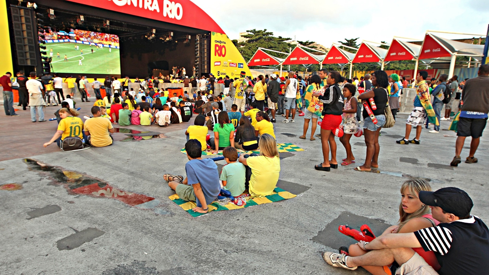 15.jun.2013 - Calmos, torcedores assistem ao jogo entre Brasil e Japão sentados no chão em Fan Fest no Rio de Janeiro