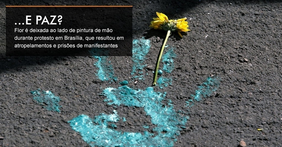 Flor é deixada ao lado de pintura de mão durante protesto em Brasília, que resultou em atropelamentos e prisões de manifestantes