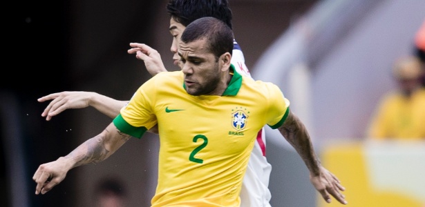 Daniel Alves encara a marcação no jogo entre Brasil e Japão