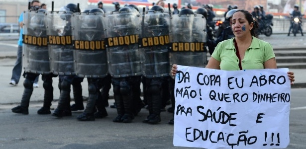 Manifestante mostra cartaz contra investimento público na Copa do Mundo