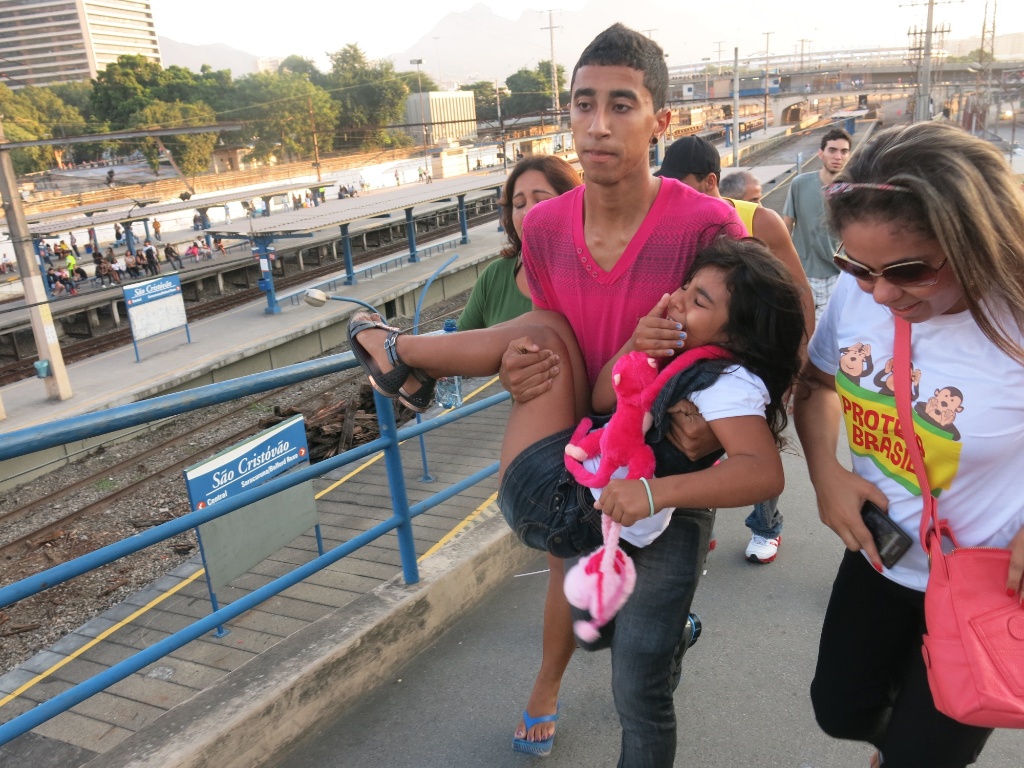 16.jun.2013 - Chorando, criança é carregada no colo durante protesto no Maracanã