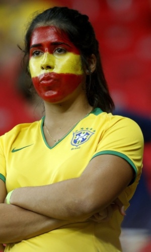 16.jun.2013 - Com camisa do Brasil e cara pintada com as cores da bandeira espanhola, torcedora aguarda início da partida entre Uruguai e Espanha na Arena Pernambuco