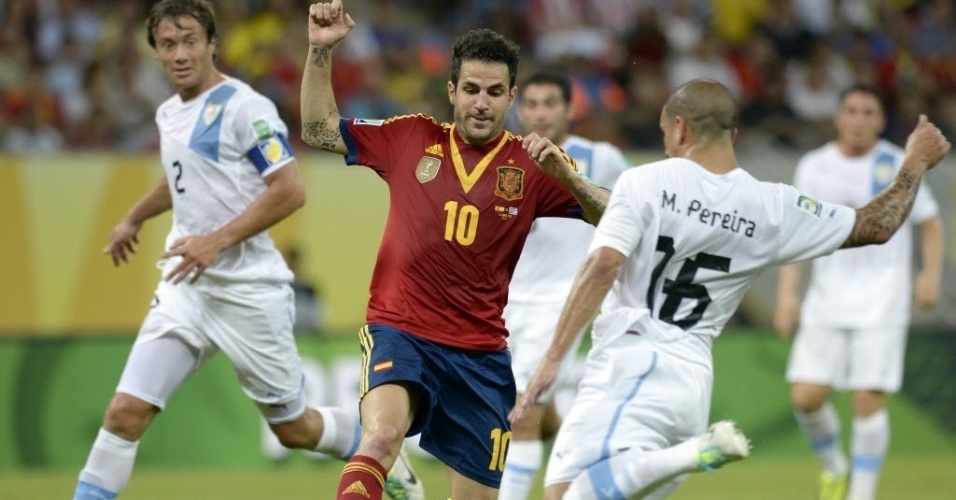 16.jun.2013 - Fàbregas e Maxi Pereira dividem a bola durante partida entre Espanha e Uruguai na Copa das Confederações