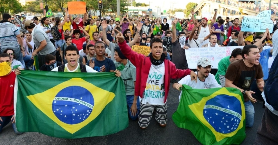 16.jun.2013 - Manifestantes se ajoelham nos arredores do Maracanã em protesto contra o reajuste no transporte público e a política no país