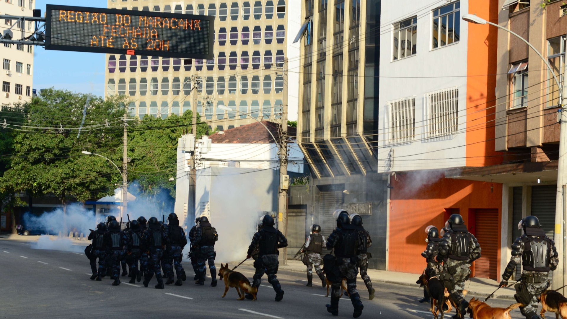 16.jun.2013 - Policias jogam bombas de gás lacrimogêneo contra protestos na região do Maracanã