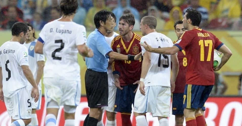 16.jun.2013 - Uruguaios e espanhóis discutem com Yuichi Nishimura, árbitro da partida