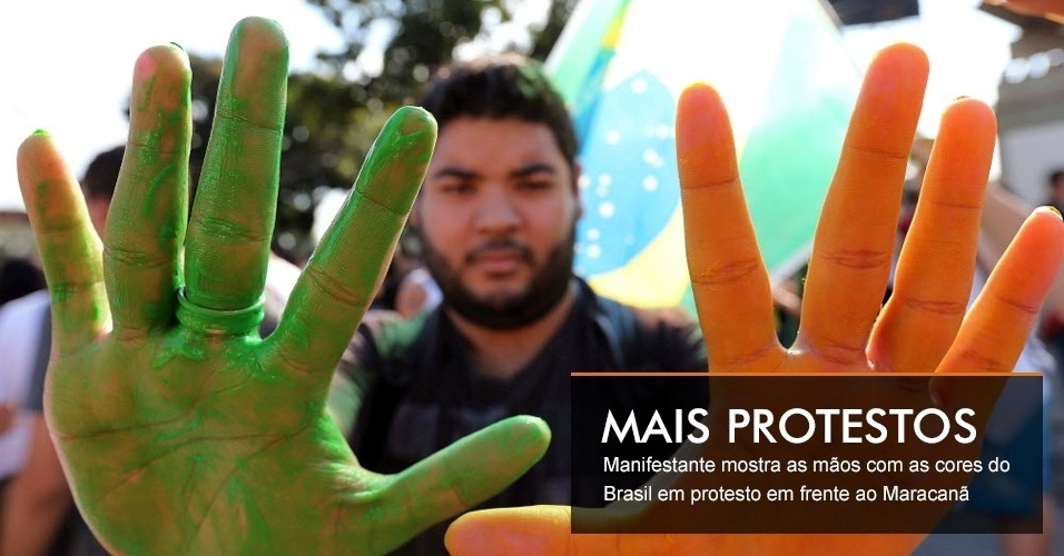 Manifestante mostra as mãos com as cores do Brasil em protesto em frente ao Maracanã
