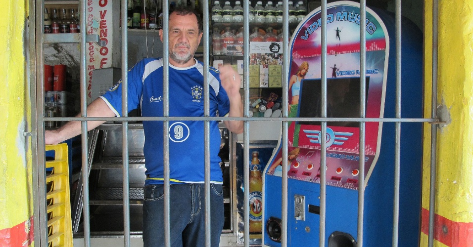 17.jun.2013 - Henrique Silva, proprietário do bar "O Paulista", se protege com grades em seu estabelecimento, localizado no pé da favela Oitão Preto