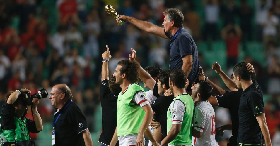 18.jun.2013 - Carlos Queiroz, treinador do Irã, é carregado pelos jogadores após a vitória por 1 a 0