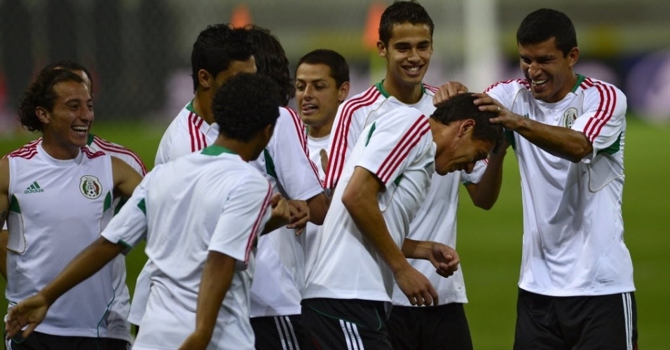 18.jun.2013 - Francisco Martinez (dir.) brinca com Hector Moreno durante treinamento da seleção mexicana em Fortaleza
