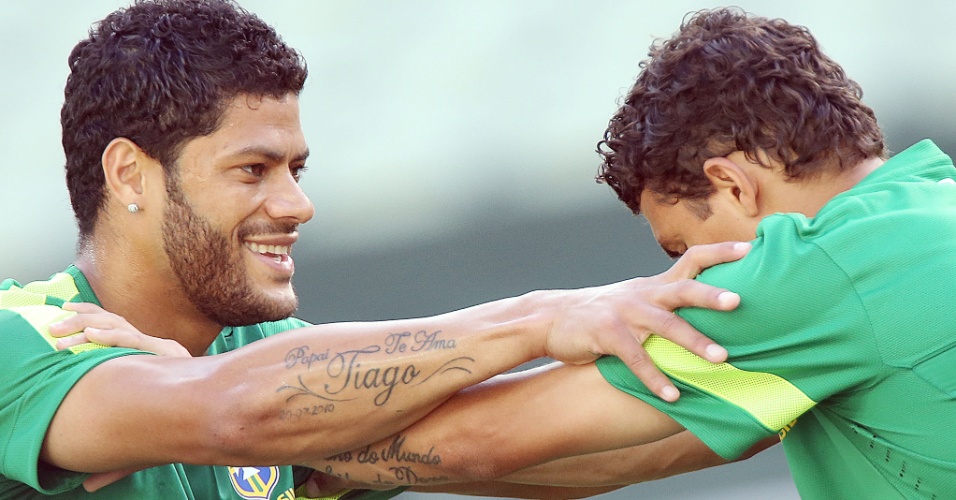 18.jun.2013 - Thiago Silva e Hulk fazem alongamento no campo em treino da seleção brasileira