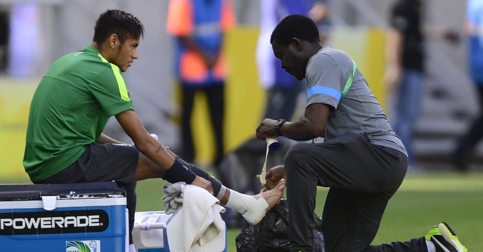 18.jun.2013 - Neymar faz coloca uma "bota" de esparadrapo antes de começar a atividade