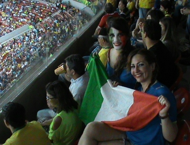 19.jun.2013 - Animadas, torcedoras da Itália exibem bandeira do país antes de partida contra o Japão