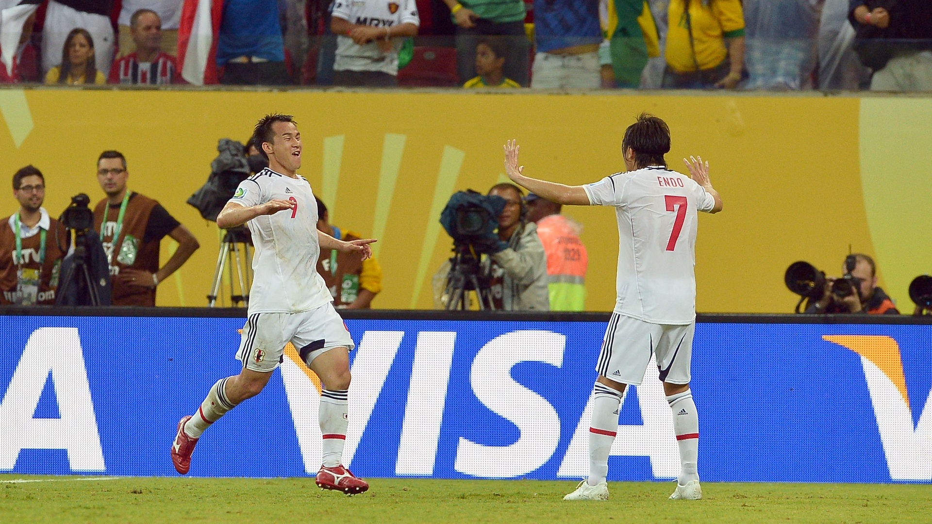 19.jun.2013 - Atacante Shinji Okazaki (esq) comemora com meia Yasuhito Endo terceiro gol do Japão contra a Itália