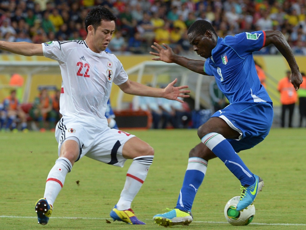 19.jun.2013 - Balotelli tenta driblar Maya Yoshida durante partida entre Itália e Japão na Arena Pernambuco
