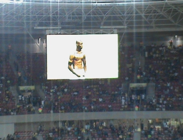 19.jun.2013 - Comemoração típica de Balotelli aparece em telão da Arena Pernambuco