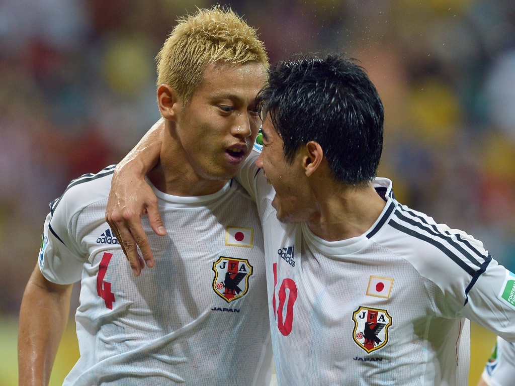 19.jun.2013 - Japonês Honda (esq) abraça companheiro Shinji Kagawa após marcar primeiro gol do Japão sobre a Itália