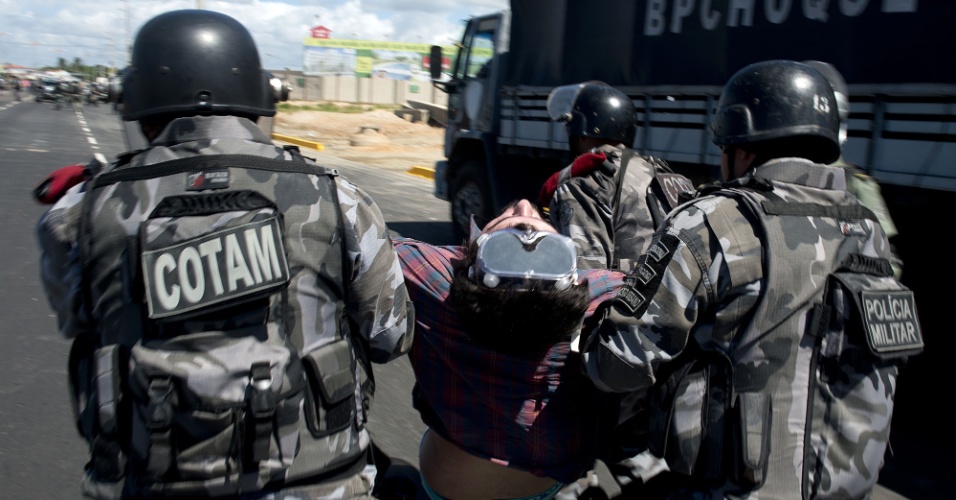 19.jun.2013 - Manifestante é arrastado por policiais durante confronto nas imediações do estádio Castelão, em Fortaleza
