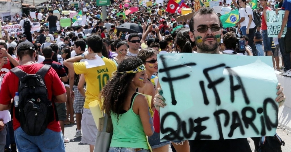 19.jun.2013 - Manifestante leva cartaz para protestar contra a Fifa em frente ao Castelão