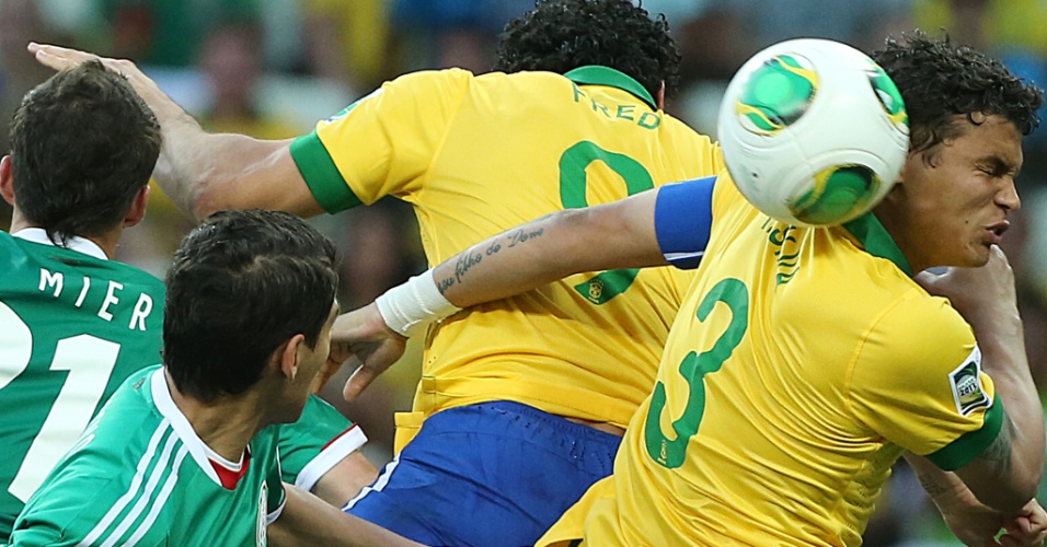 19.jun.2013 - Thiago Silva e Fred sobem para tentar cortar um cruzamento durante a partida entre Brasil e México