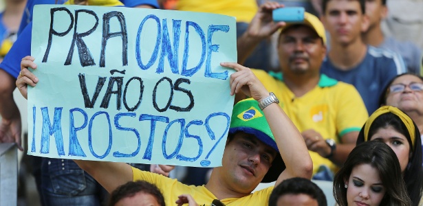 Torcedor mostra cartaz com protesto no jogo entre Brasil e México, em Fortaleza, que decretou feriado no dia