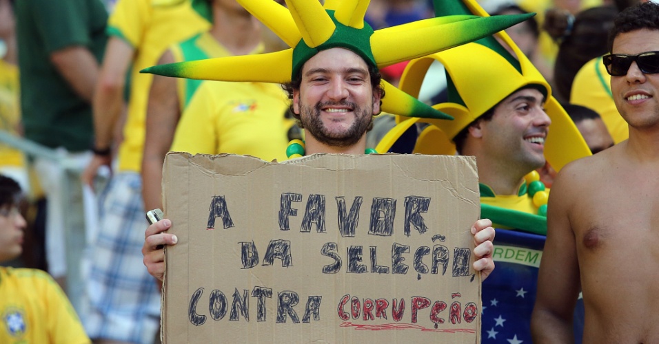 19.jun.2013 - Torcedor protesta contra a corrupção, mas apoia a seleção antes do duelo entre México e Brasil em Fortaleza