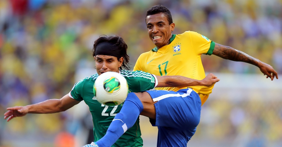 19.jun.2013 - Volante Luiz Gustavo tenta se antecipar e tirar a bola do mexicano Gerardo Flores