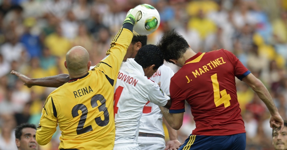 20.junho.2013 - Reina, goleiro da Espanha, soca a bola para tirá-la da cabeça de jogador do Taiti