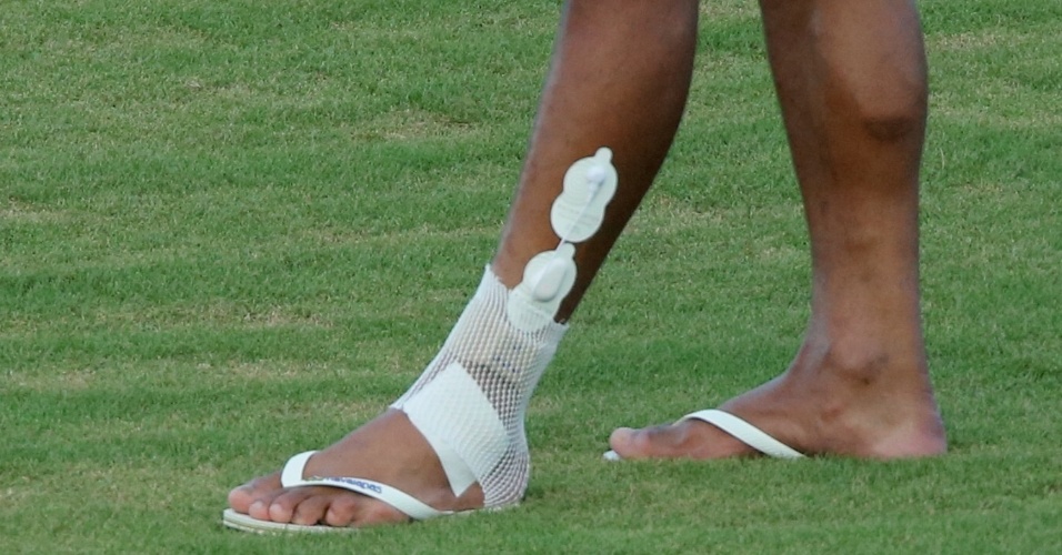 21.jun.2013 - Paulinho caminha no gramado com proteção no tornozelo lesionado