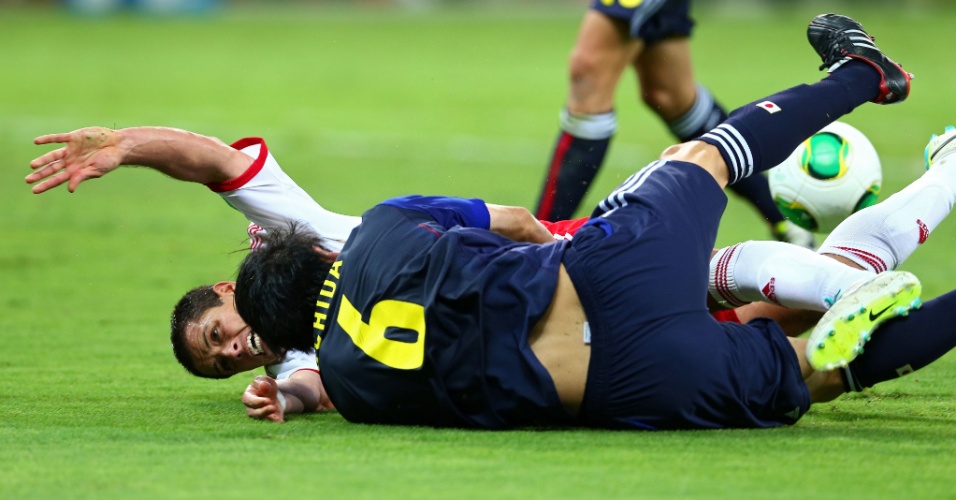 22.06.13 - Atsuto Uchida e Javier Hernandez caem no gramado após se chocarem na partida entre Japão e México pela Copa das Confederações