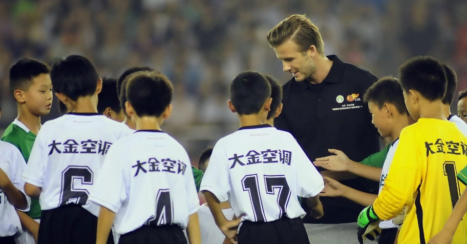 Inglês David Bekcham brincou com crianças chinesas neste sábado, durante jogo da liga chinesa em Hangzhou