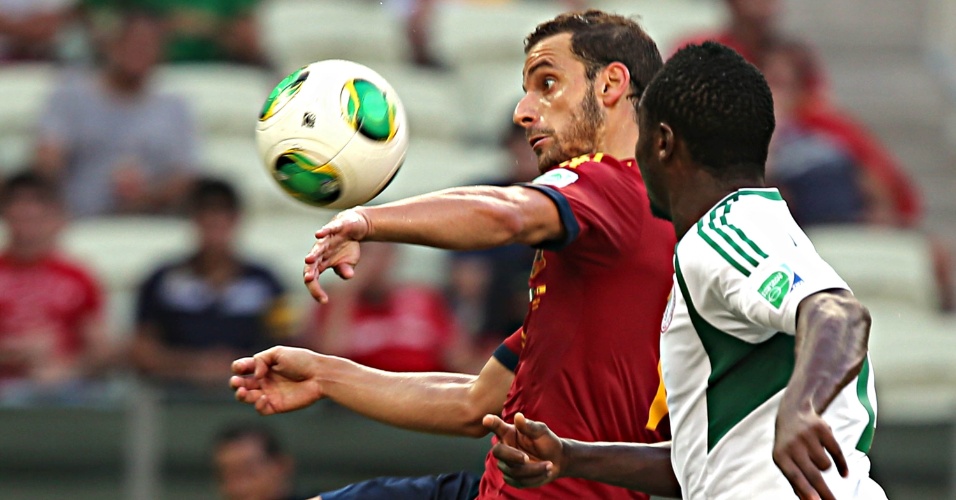 23.jun.2013 - Jogador da Espanha protege a bola de marcador nigeriano
