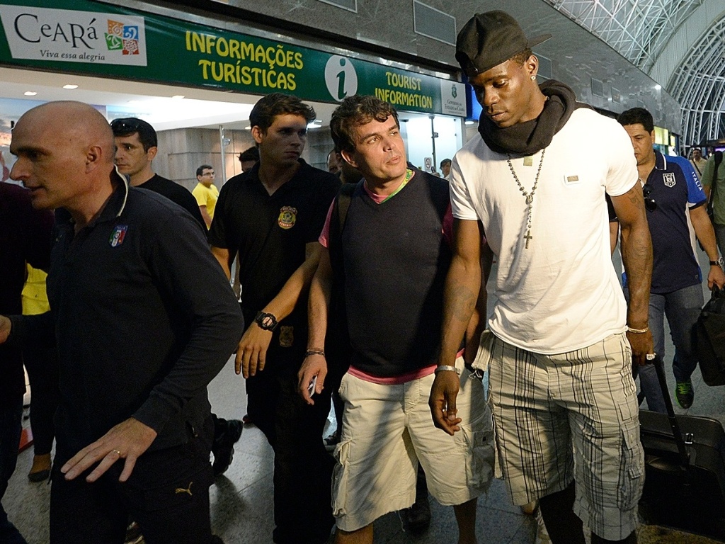 24.jun.2013 - Rodeado por seguranças, Balotelli caminha em aeroporto de Fortaleza