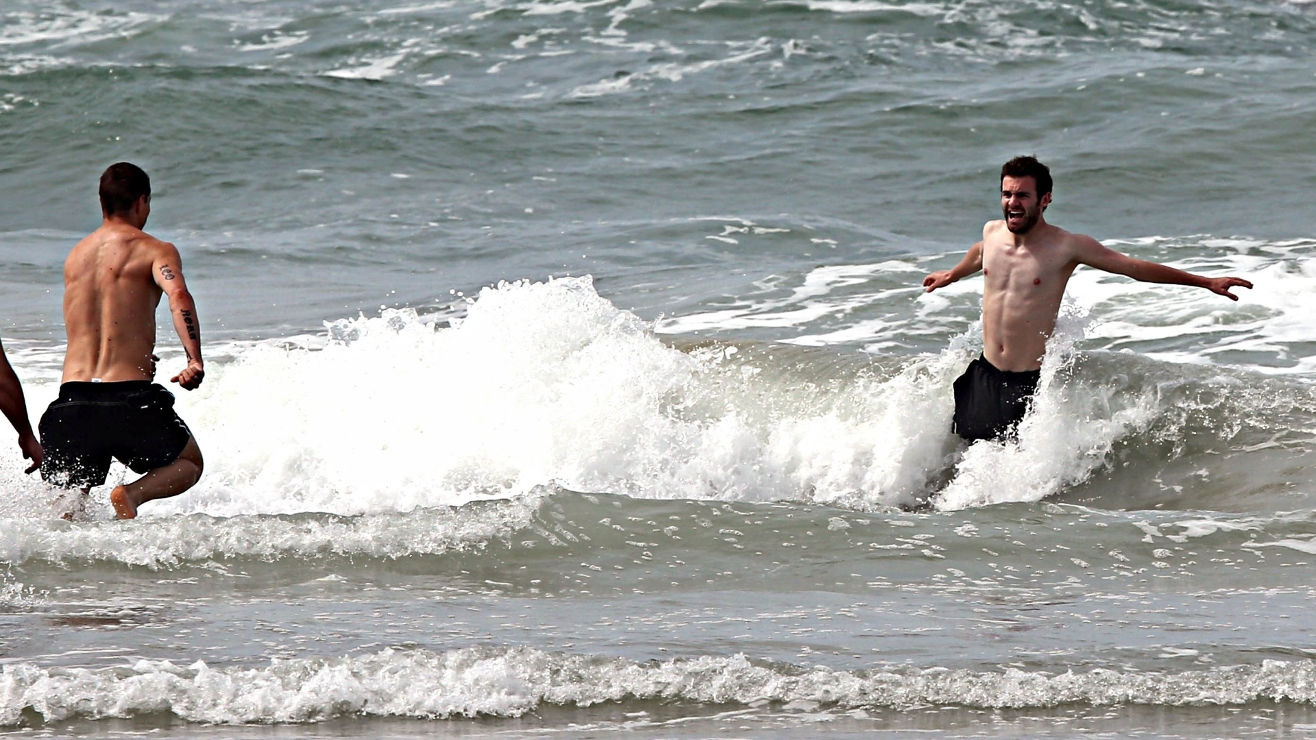 24.jun.2013 - Torres (e) e Juan Mata brincam nas águas da Praia do Futuro