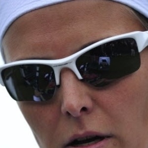 24.jun.2013 - A belga Kirsten Flipkens joga de óculos escuros em sua estreia em Londres - AFP PHOTO / GLYN KIRK