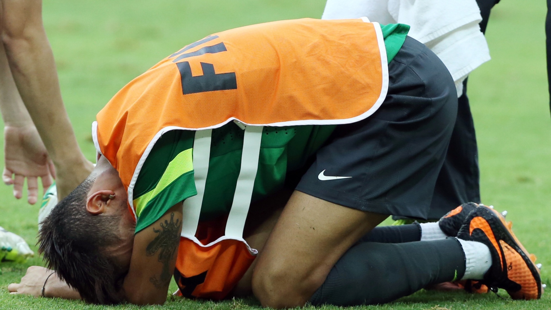 25.jun.2013 - Caído no gramado, Neymar sente dores após dividida com volante Fernando em treino da seleção brasileira