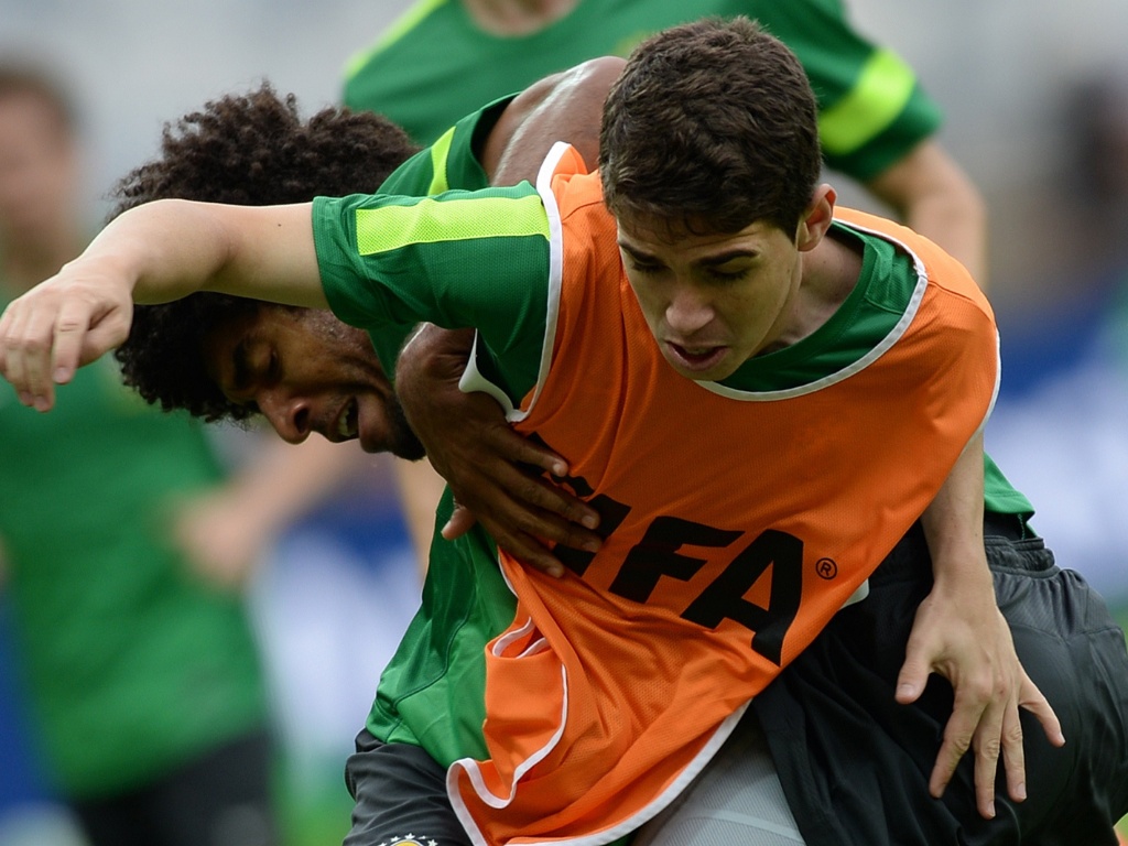 25.jun.2013 - Zagueiro Dante tenta desarmar meia Oscar durante treino da seleção brasileira
